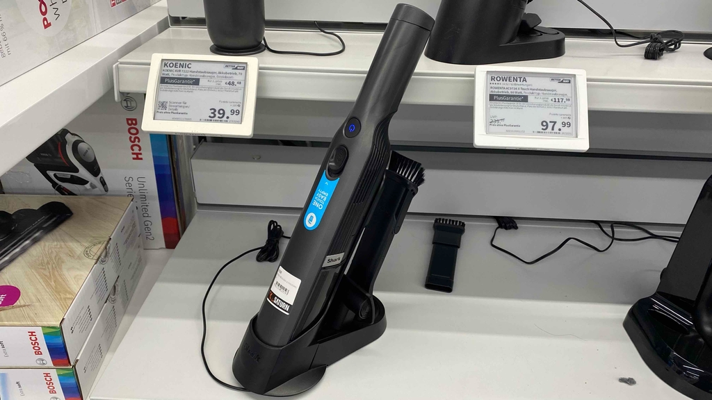 Ein Shark Handstaubsauger steht zum testen auf einem weißen Verkaufsregal.