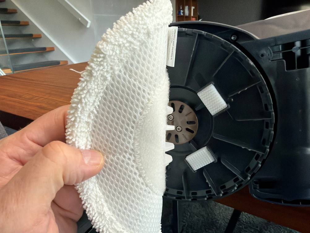 Eine Hand entfernt einen Stoff von der Spitze vom Shark S8201EU