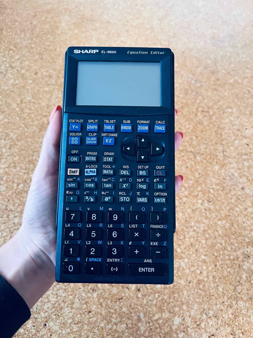 Hand hält einen getesteten grafischen Taschenrechner von Sharp.