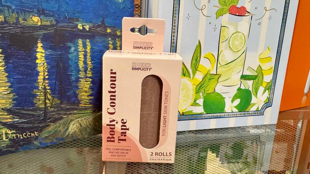 Body-Tape-Test: Zwei Rollen Brust-Tape in der Farbe Haut befinden sich in einem Verpackungskarton mit Sichtfenster auf einem Verkaufsregal.