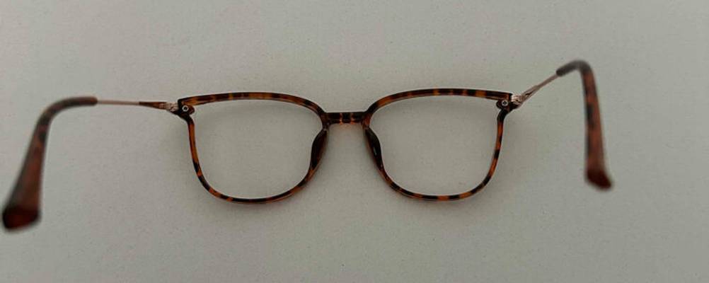 Blaulichtfilter-Brillen im Test: eine Brille mit Schildpatt-Rahmen liegt mit geöffneten Bügeln auf ihren Gläsern.