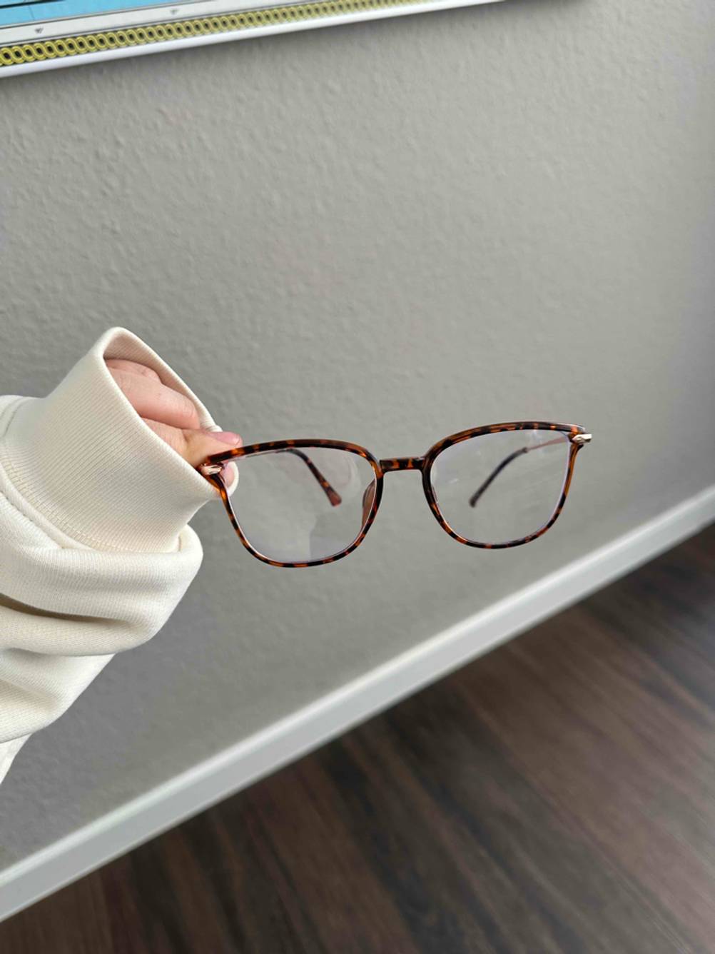 Eine Hand hält eine Blaulichtfilter-Brille zum Testen.