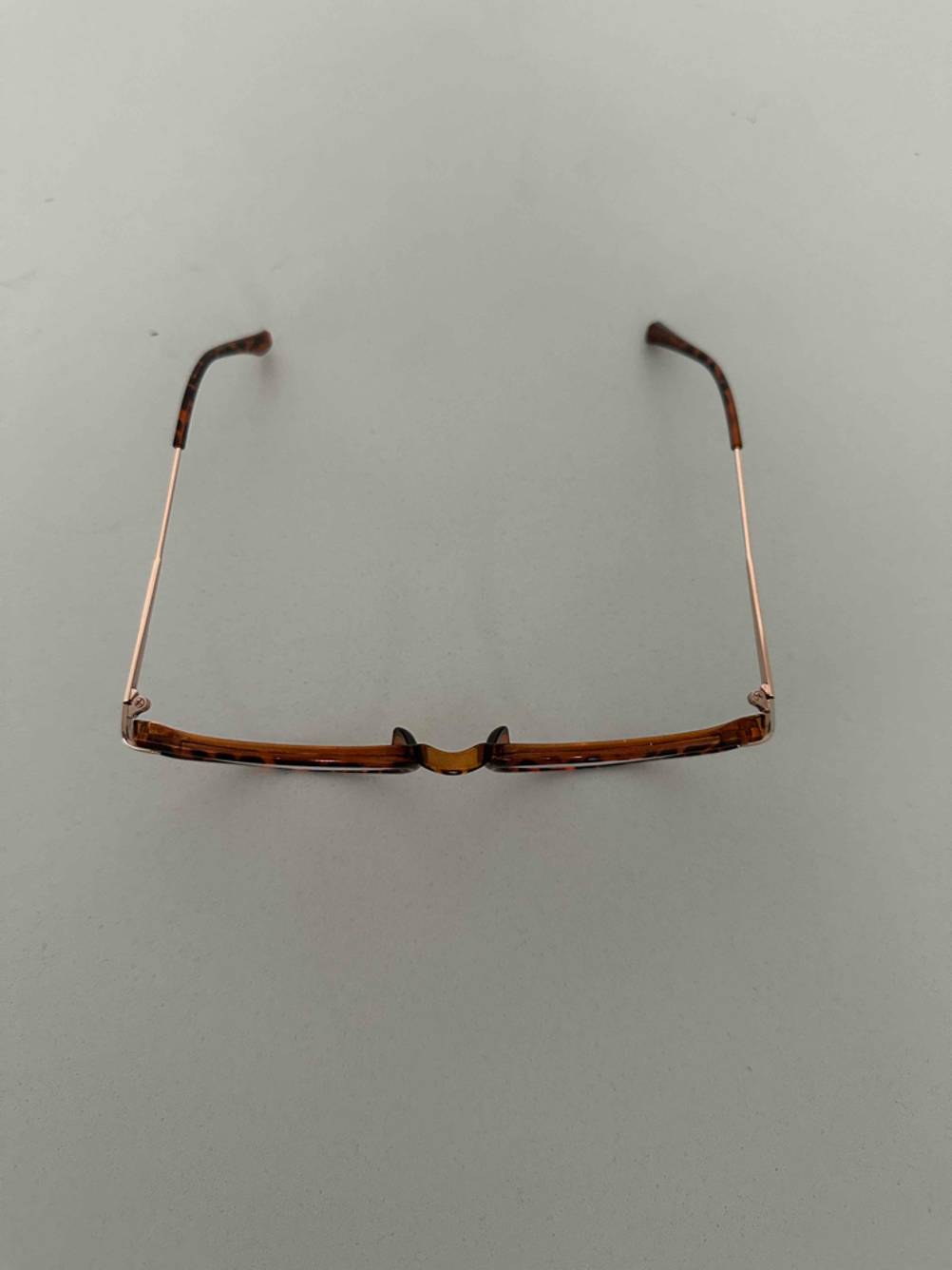 Ansicht von oben auf eine getestete Blaulichtfilter-Brille mit Vollrahmen im Horn-Design auf einer grauen Oberfläche.