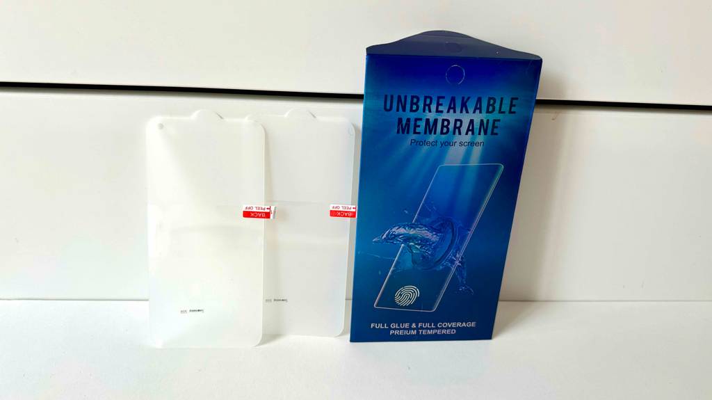 Eine blaue Verpackung mit einem Samsung-Galaxy-S10-Panzerglas im Test steht an einer weißen Wand.