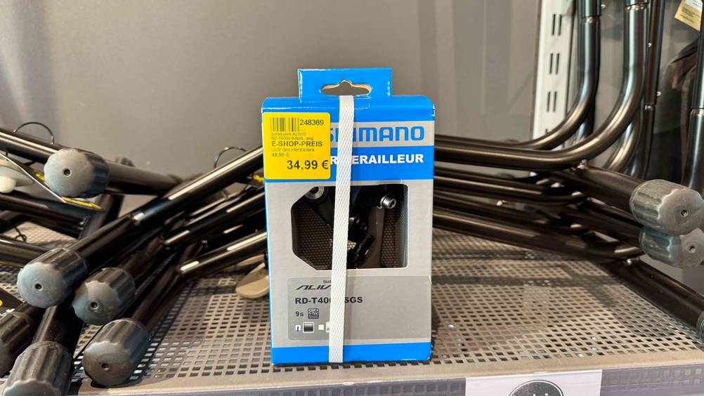In einem Rgal mit anderen Produkten steht eine Packung des Shimano-Schaltwerks im Test.