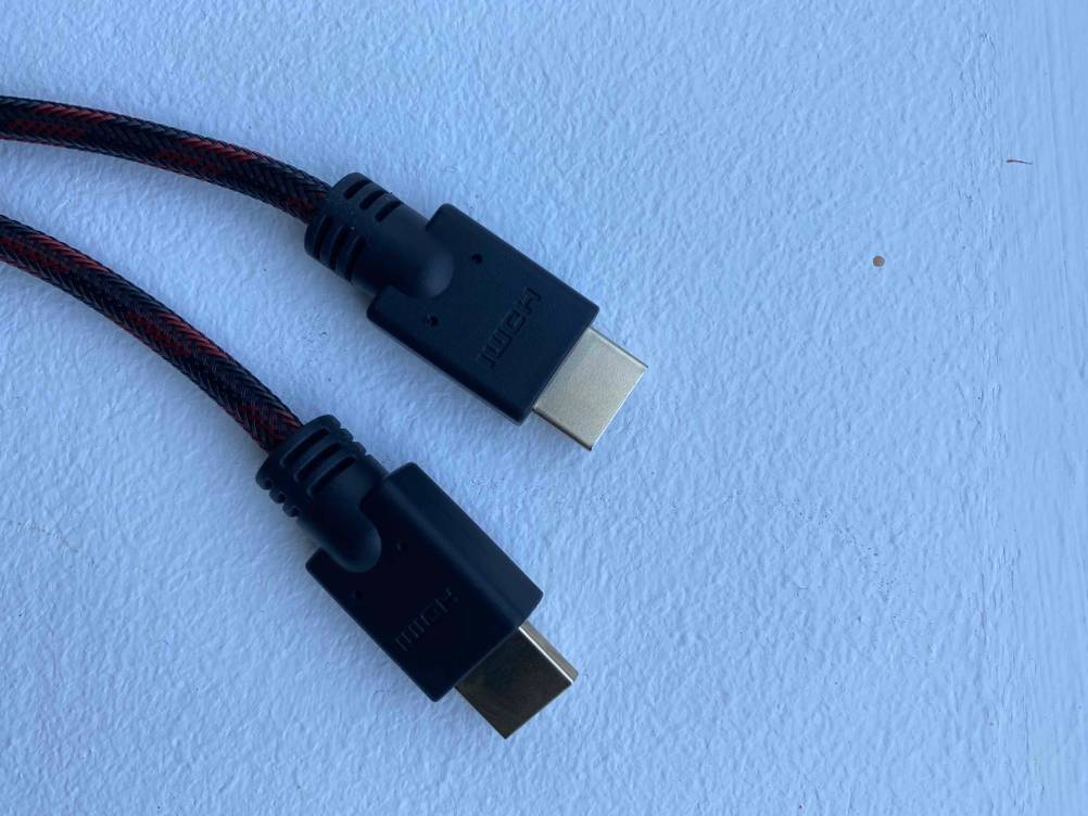 Nahaufnahme der USB-Anschlussstecker von einem schwarzen, getesteten 3m-HDMI-Kabel vor hellblauem Hintergrund.
