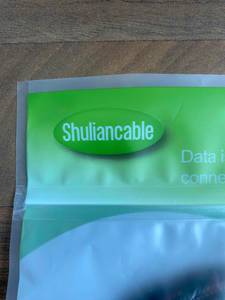 3m-HDMI-Kabel im Test: Detailansicht einer blau-grünen Kunststoffverpackung der Marke Shuliancable.