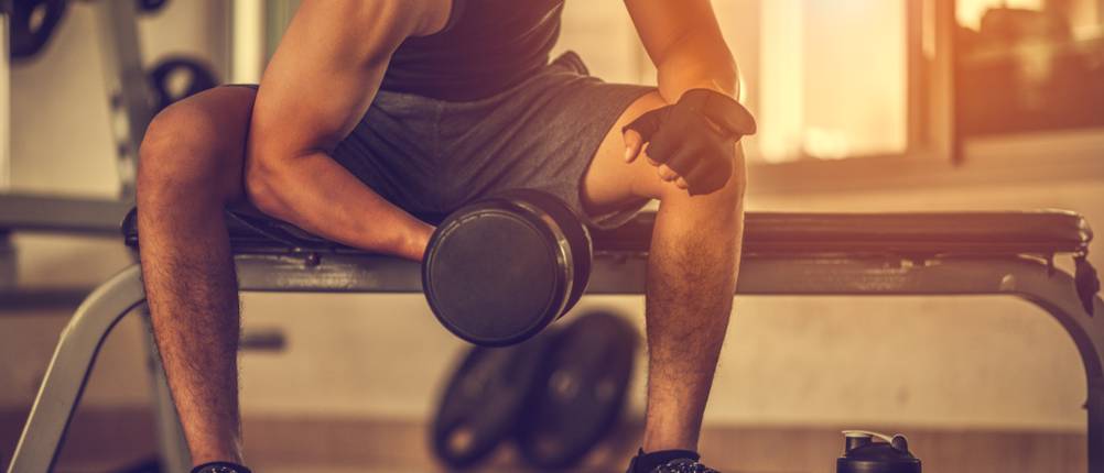 Fitness-Handschuhe-Herren-Test: Ein Mann trainiert mit einer Hantel seine Arme.
