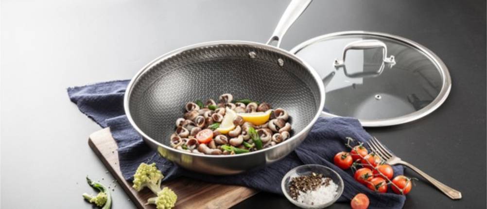 Wokpfanne mit Deckel und zubereiteter Mahlzeit