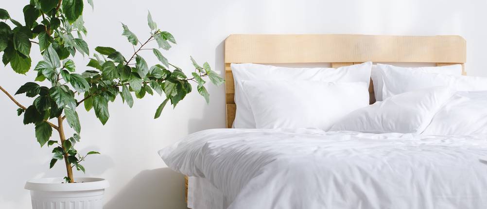 Bettlakenspanner-Test: Zu sehen ist ein ordentlich gemachtes Bett mit weißem Bettzeug.