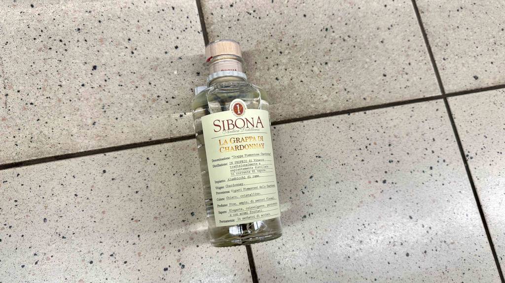 Getestet: Chardonnay Grappa in der Flasche mit Holzkorken liegt auf einem Fliesenbelag.