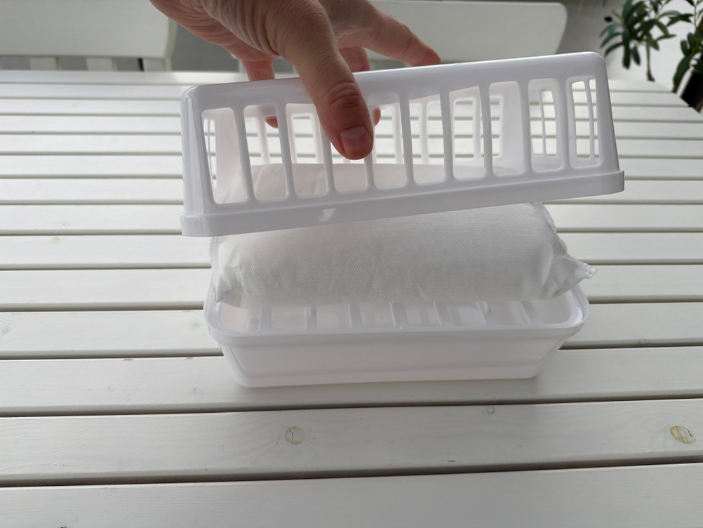 Eine Hand setzt den Deckel auf einen Luftentfeuchter mit einer Packung aus dem Sichler NC5963-944