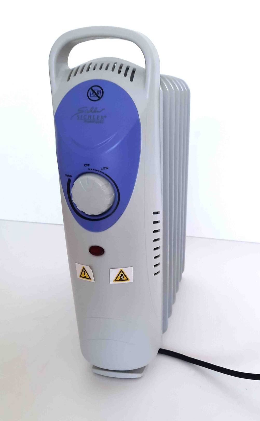 Ein Ölradiator im Test von vorne mit Kabel auf einer hellen Fläche.