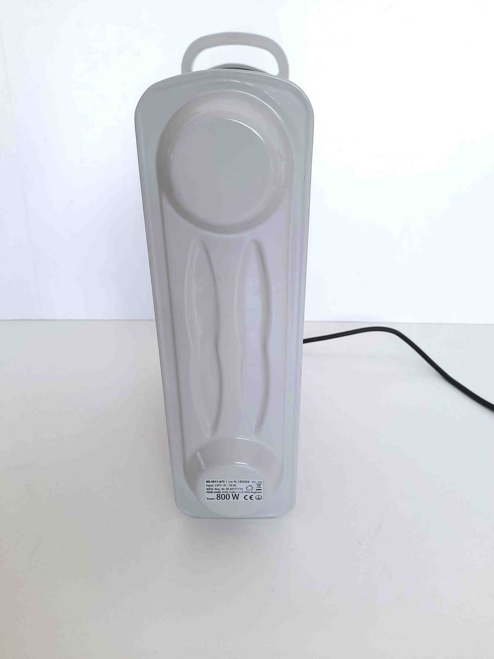 Rückseite eines getesteten Ölradiators mit Kabel vor einer hellen Wand.