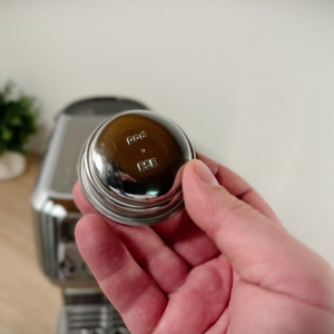 Ein Ese-Pod-Sieb für die Caso-Siebträegermaschine wird hochgehalten.