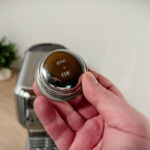 Ein Ese-Pod-Sieb für die Caso-Siebträegermaschine wird hochgehalten.