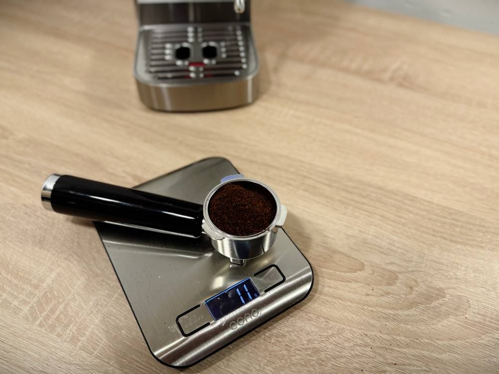 Ein Siebträger liegt auf einer Waage.