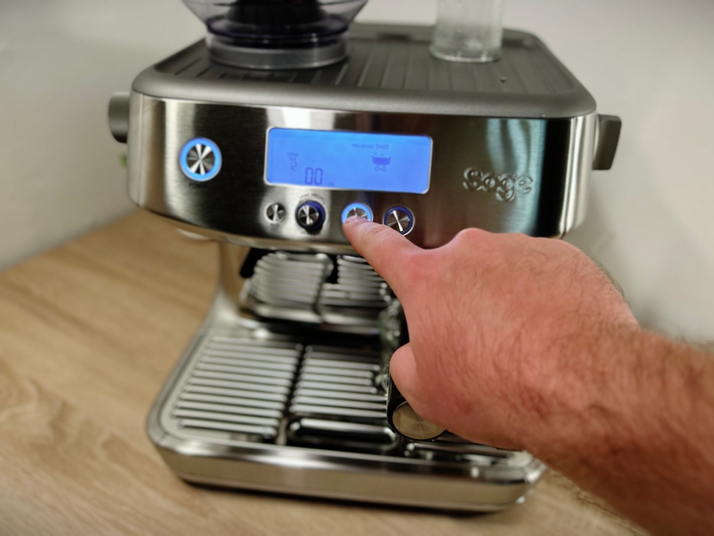 Eine Hand bedient die Siebträgermaschine von Sage für einen Single-Shot-Espresso.