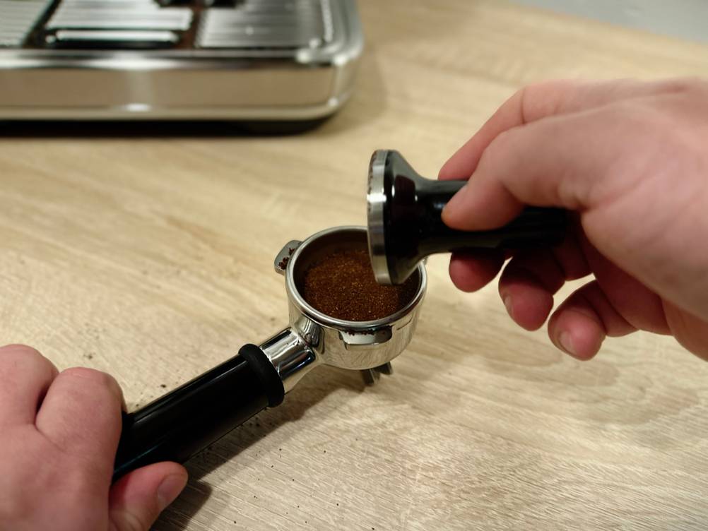 Mit einem Tamper wurde das Kaffeemehl in einem Siebträger gefestigt.