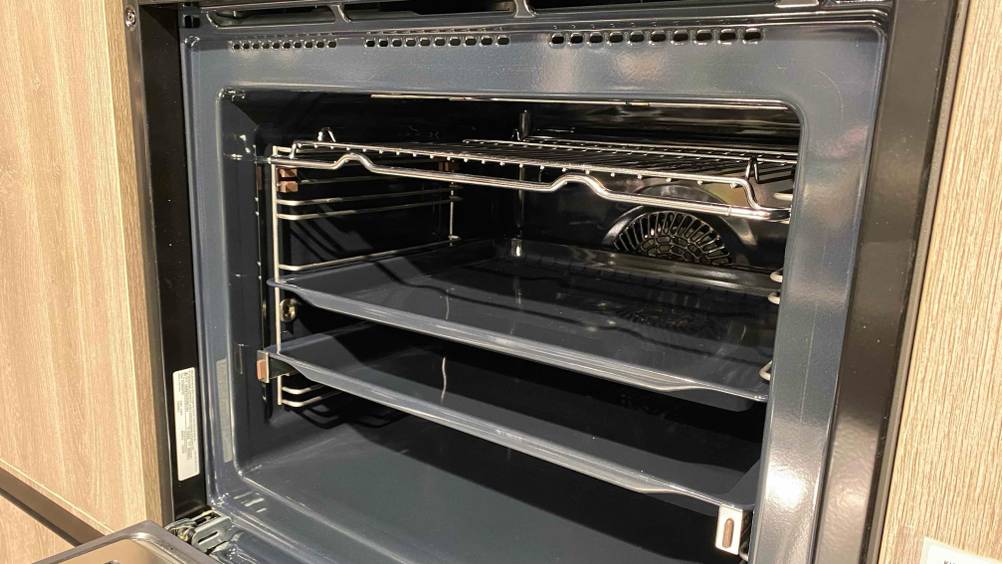Im Test: Nahaufnahme des Innenraums eines Backofens mit Mikrowelle und Blechen.