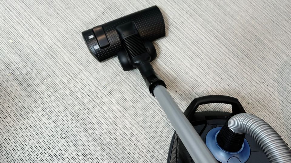 Der Siemens extreme silencePower VSQ5X1230 Staubsauger ist während des Betriebs auf einem Teppich zu sehen. Die Bodendüse ist vollständig ausgezogen und in Bewegung.