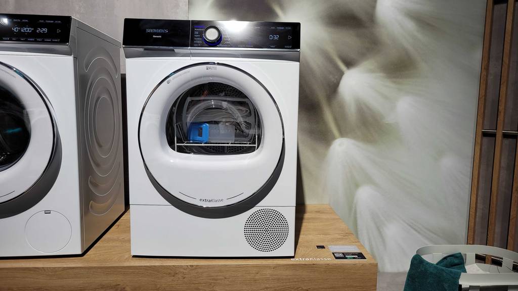 Zwei verschiedene Siemens-Trockner im Test befinden sich auf einer Holzoberfläche. 