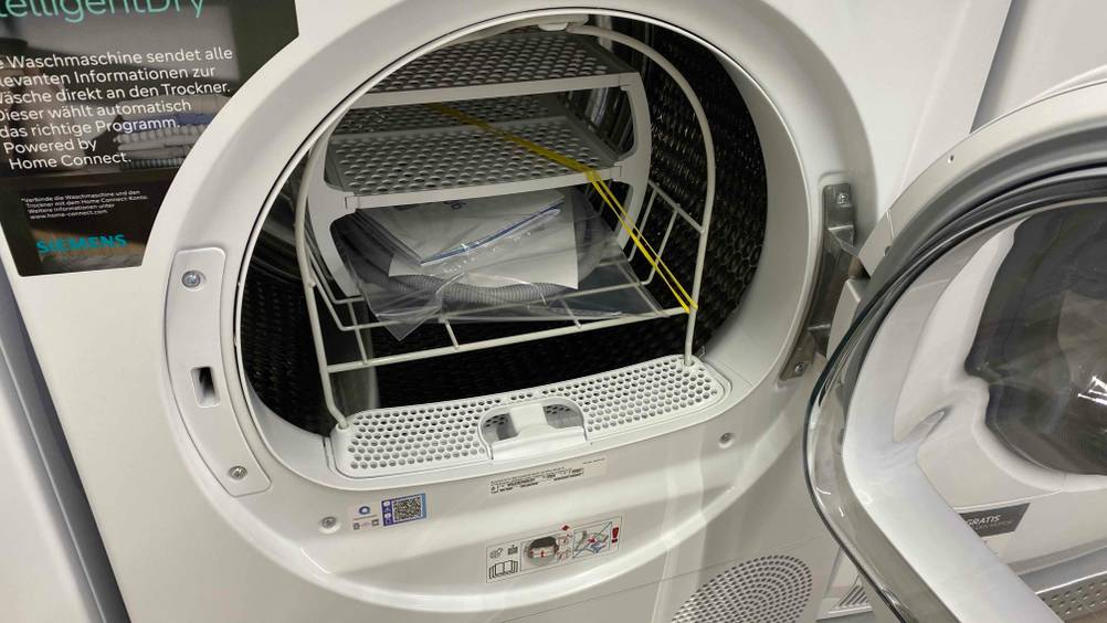 Nahaufnahme des Innenraumes mit Zubehör bei geöffneter Klappe eines Siemens-Trockners.