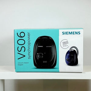 Die Vorderseite der Siemens VS06B1110 Verpackung zeigt das Gerät mit Produktname „VS06 synchropower“. Das Design ist zweifarbig mit blauem und weißem Abschnitt.