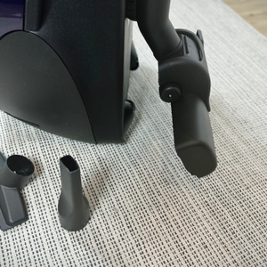 Das Bild zeigt das Zubehör des Siemens VS06B1110 Staubsaugers, bestehend aus Polsterdüse, Fugendüse und Universaladapter. Die Düsen liegen vor dem Gerät auf einem Teppich.