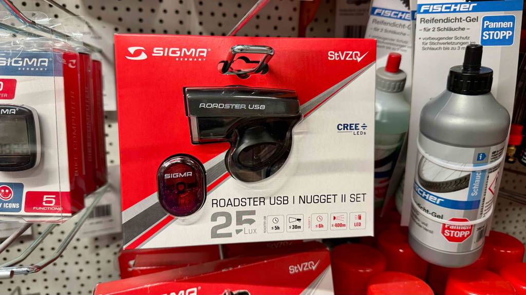Ein Sigma-Fahrradlicht hängt zum testen in einem Regal zwischen anderen Fahrradprodukten.
