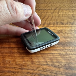 Eine Folie wird vom Display des Sigma Sport BC 10.0 WL abgezogen