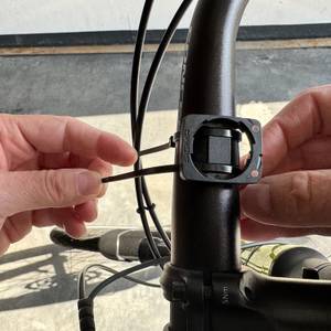 Eine Hand befestigt den Halter des Sigma Sport BC 10.0 WL am einem Fahrradlenker