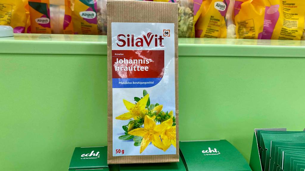 Eine Packung SilaVit Johanniskraut-Tee steht zum Testen vor einem grünen Hintergrund.