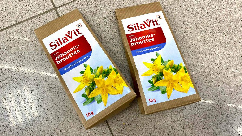 Zwei Packungen getesteter Johanniskraut-Tee liegen nebeneinander auf Fliesen.