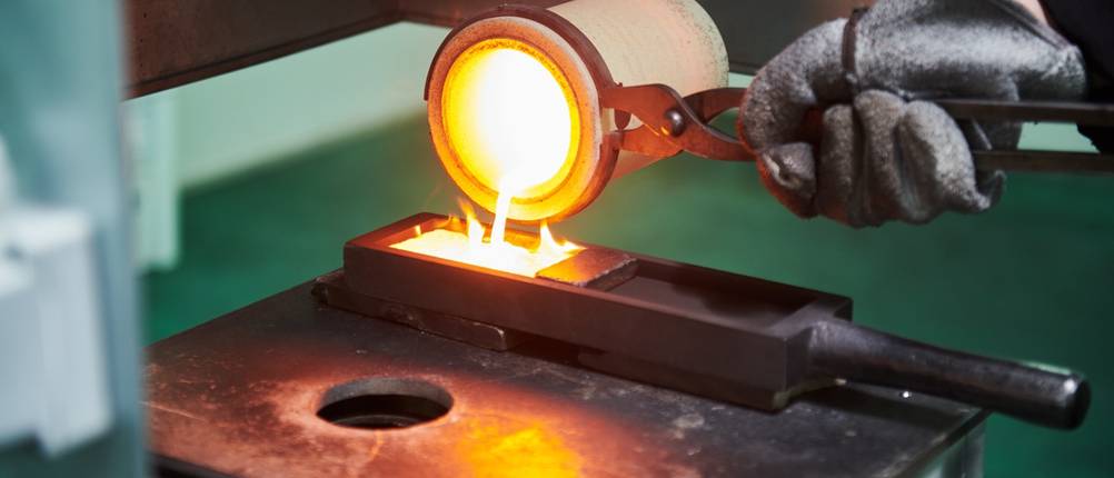 Flüssiges Metall wird aus einem Schmelztiegel in eine Form gegossen.
