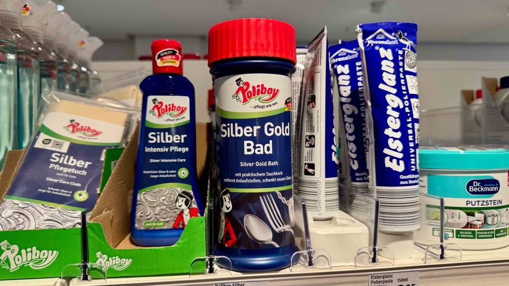Mehrere Packungen des getesteten Silberbades stehen neben anderen Produkten in einem Verkaufsregal.