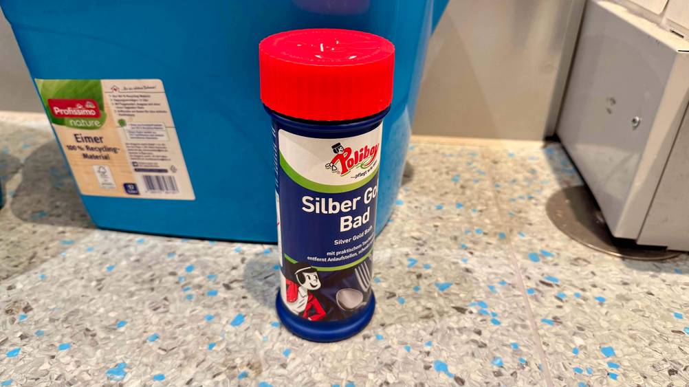 Das getestete Silberbad steht auf dem Boden vor einem blauen Eimer.