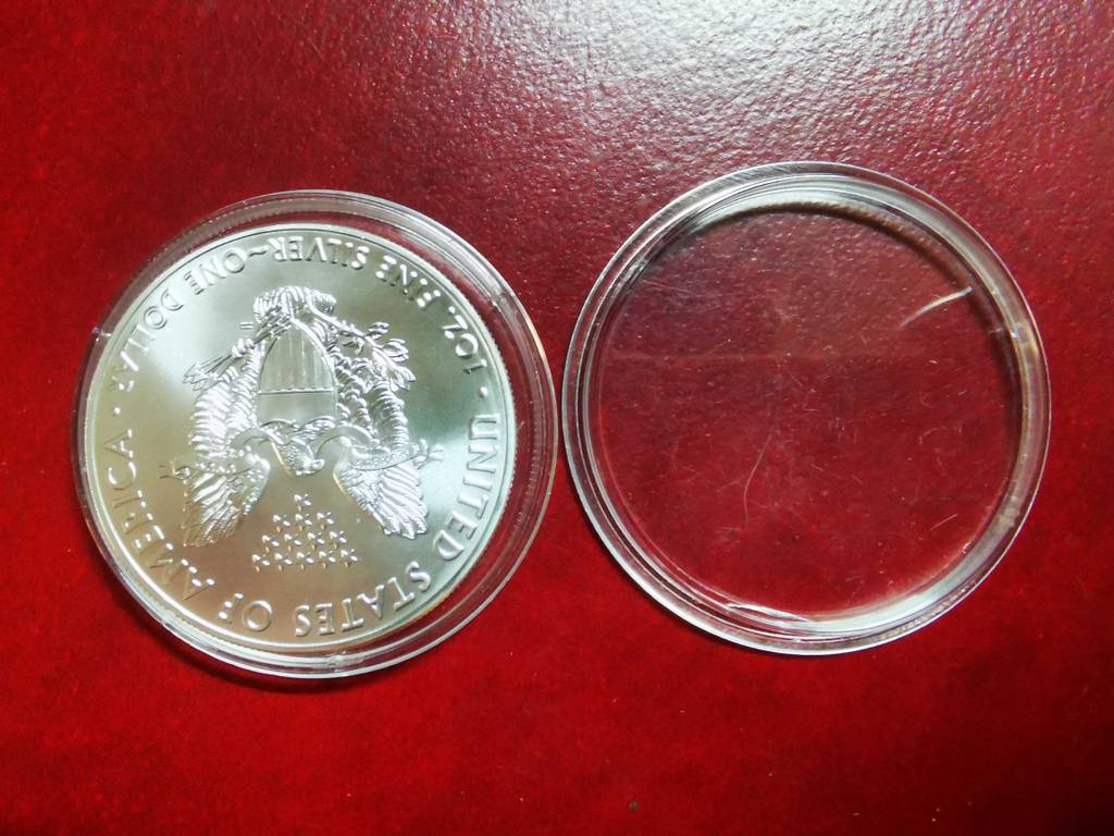 Silbermünze im Test: Der Deckel der Box liegt neben der Münze.