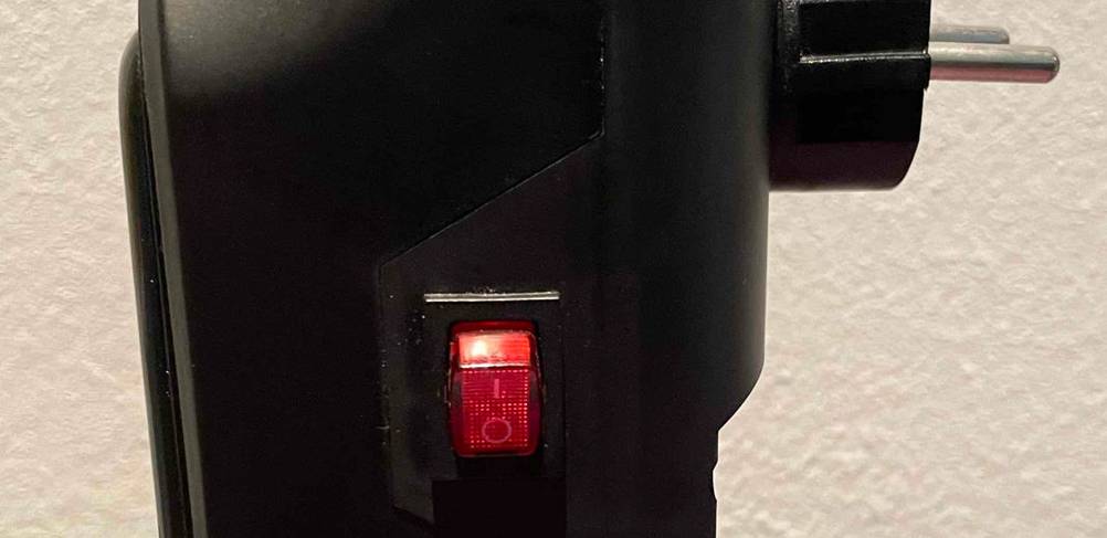 Nahaufnahme der LED-roten Einschalttaste von einem schwarzen Mini-Heizlüfter im Test.