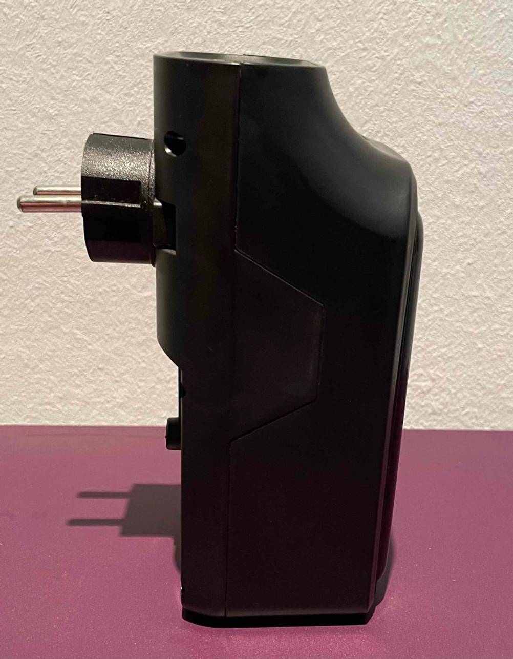Seitliche Ansicht auf einen schwarzen Mini-Heizlüfter im Test, der über einen Schuko-Stecker verfügt.