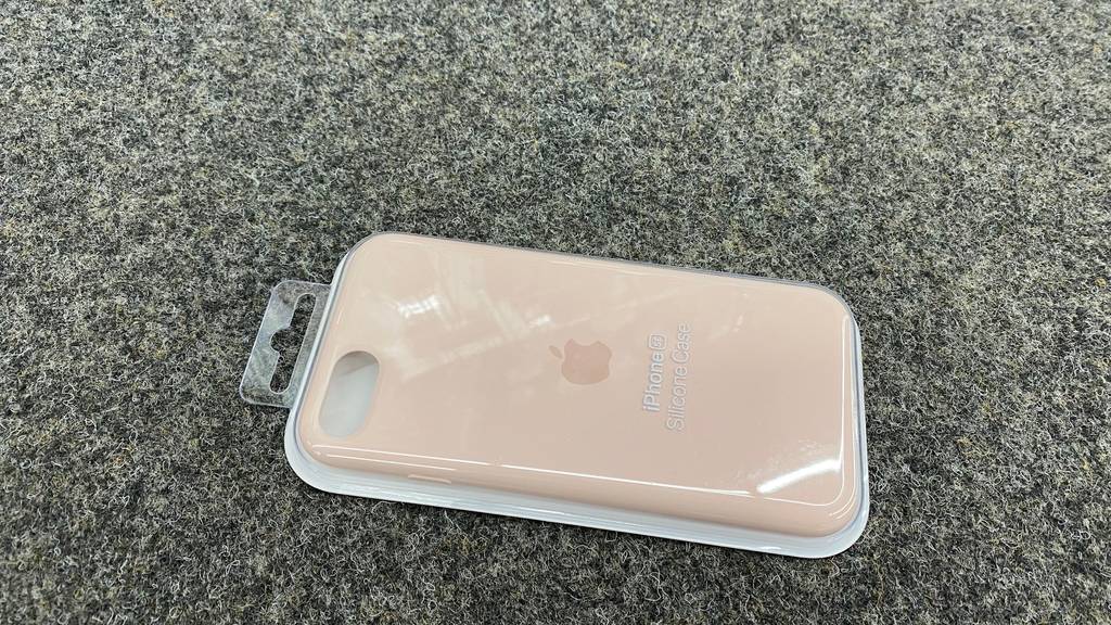 Im Test: beige IPhone SE Hülle liegt quer auf dunkler Fläche.
