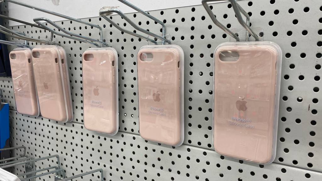Im Test: Mehrere IPhone SE Hüllen hängen nebeneinander in einem Regal.