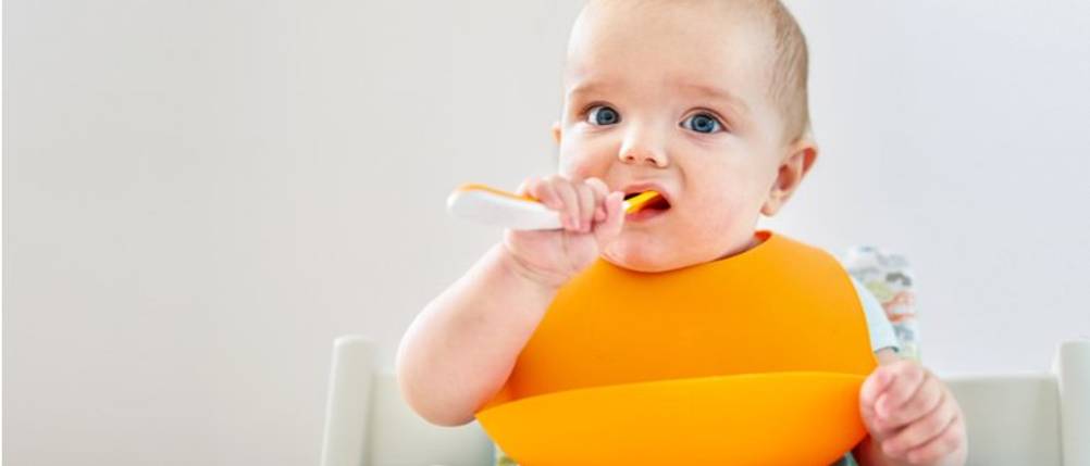 ein Baby mit einem Silikon-Lätzchen