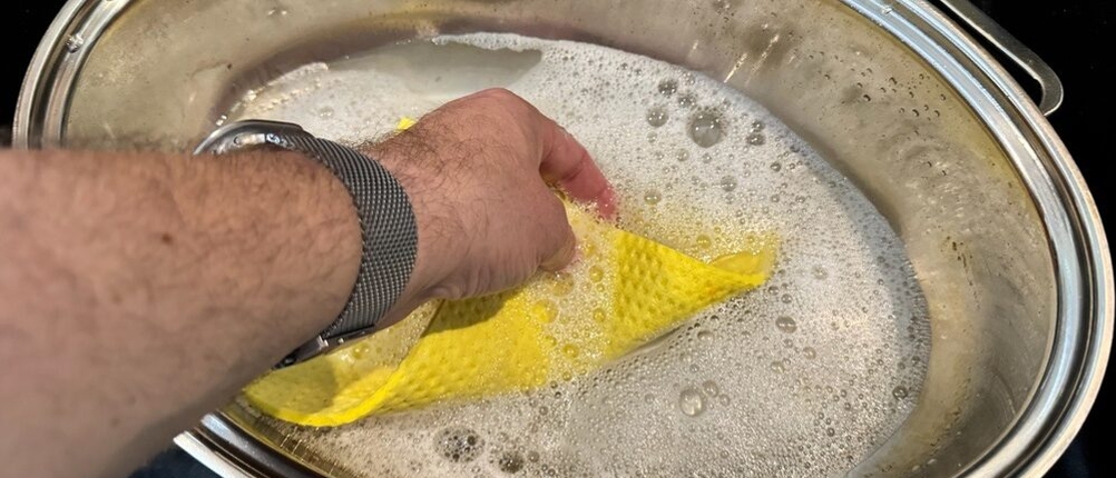 Eine Hand reinigt den Behälter des Silit 2136283911 mit einem Lappen und Wasser