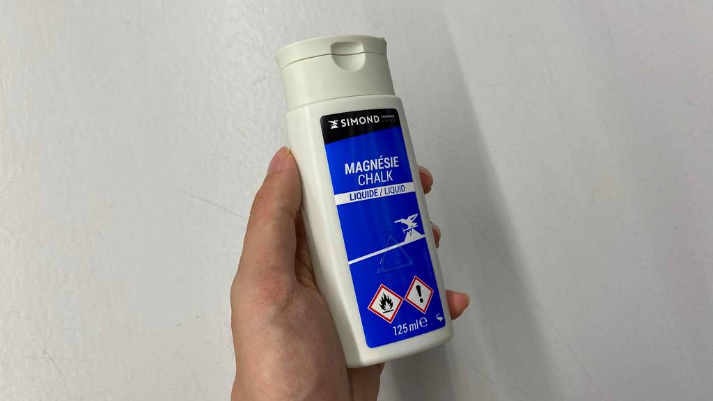 Im Test: Hand hält Liquid Chalk von Simon vor weißer Wand.