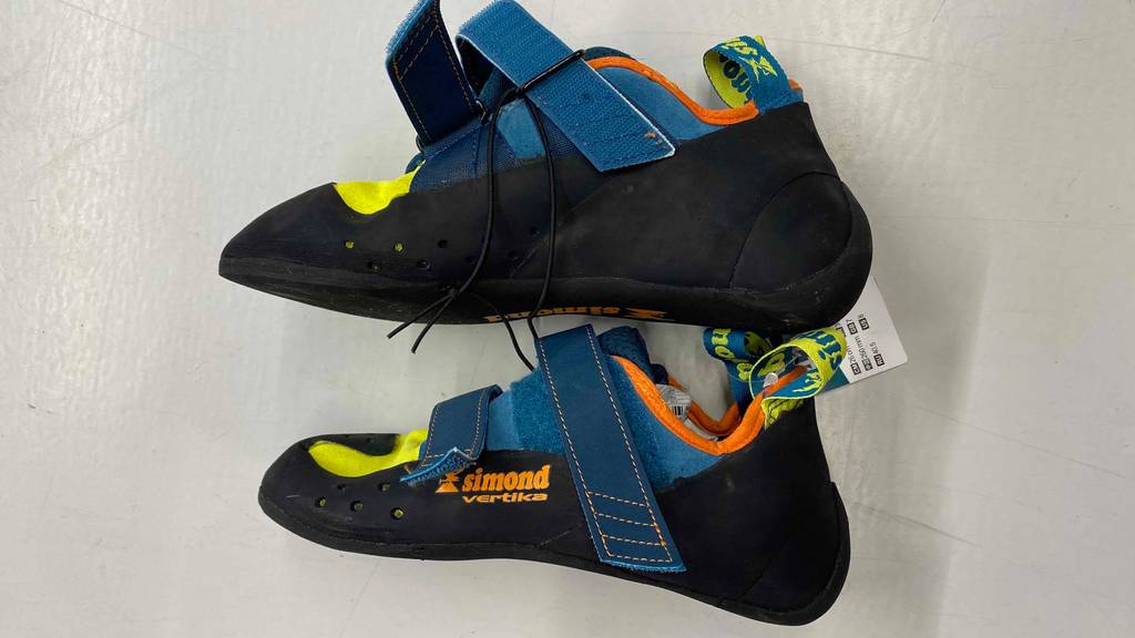 Im Test: Ein Paar Kletterschuhe von Simond liegen seitlich übereinander auf weißer Fläche.