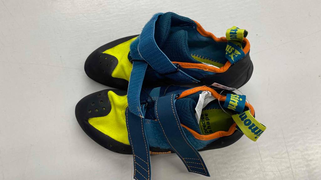 Im Test: mehrfarbige Kletterschuhe von Simond mit geöffnetem Klettverschluss auf weißer Fläche.