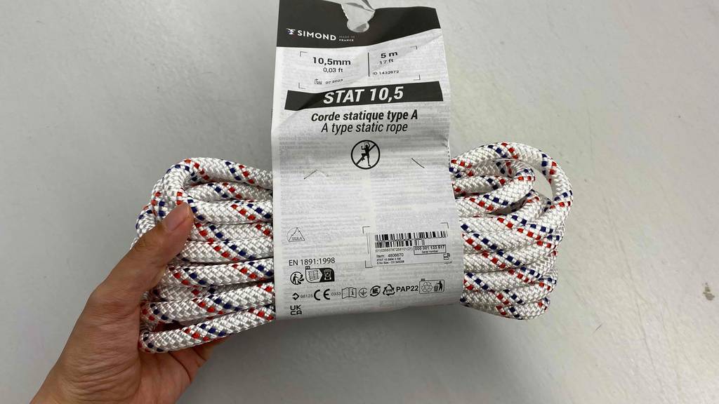 Im Test: Hand hält ein Kletterseil von Simond vor weißer Wand.
