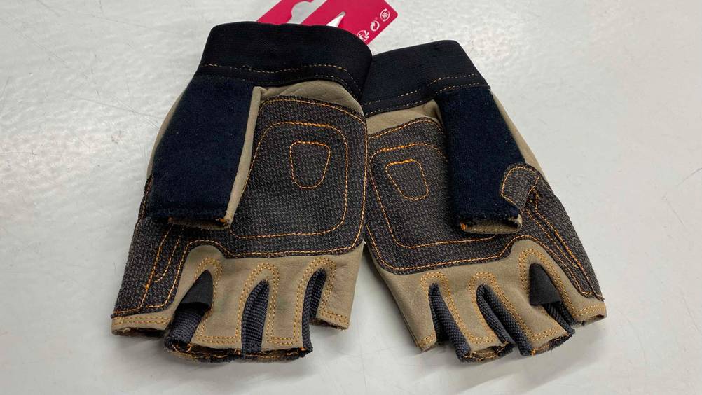 Ein Paar getestete Klettersteighandschuhe liegt mit der Innenseite nach oben auf weißer Fläche.