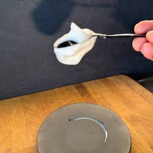 Milchschaum vom Simpletaste-Milchaufschäumer hängt an einem Löffel